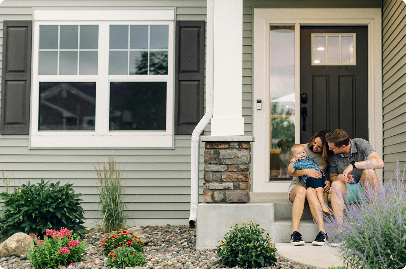 Family enjoying time together on the porch of their furnished home